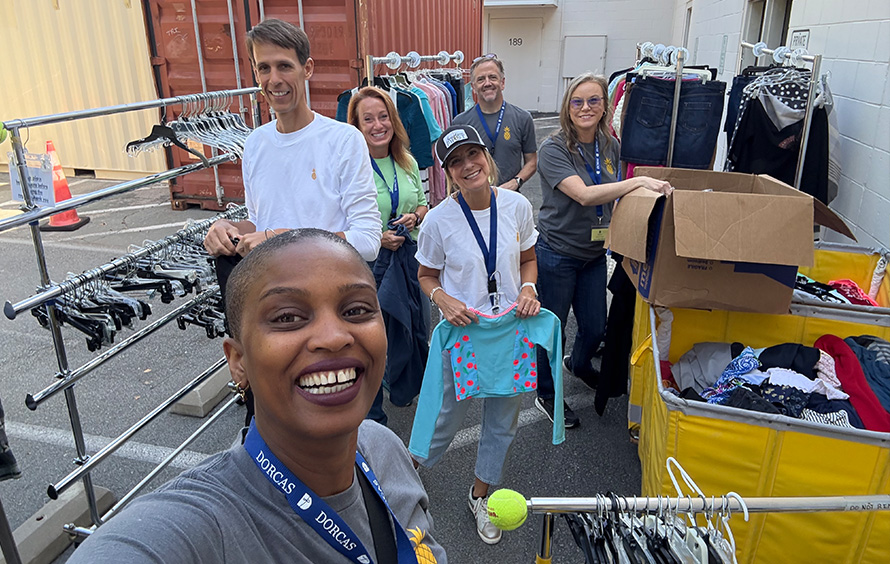 Selfie featuring several team members volunteering and organizing donated clothing.