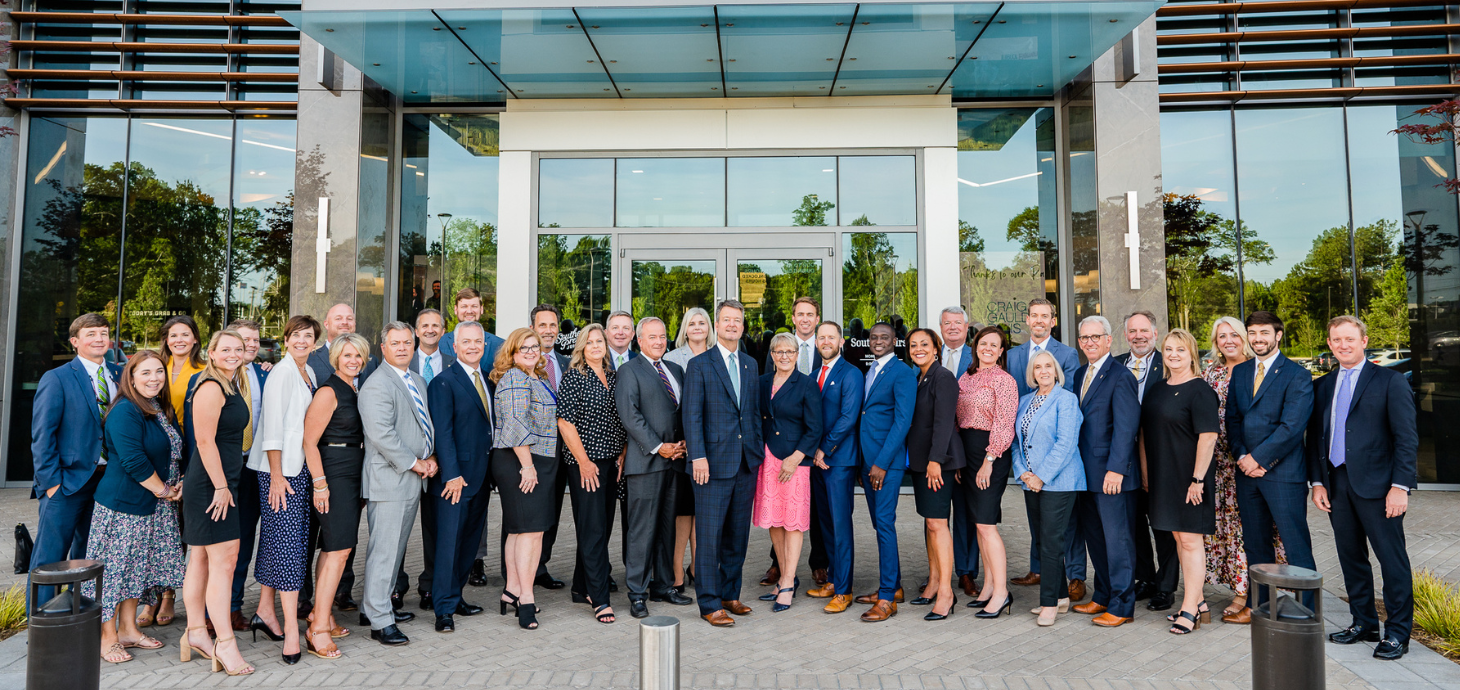 Group of Southern First bankers posing in front of the Headquarters office.