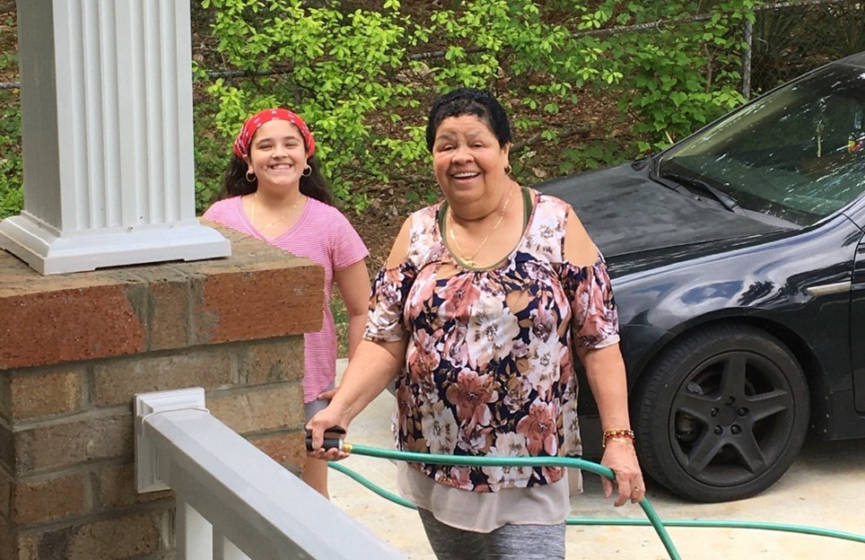Amanda with her daughter outside washing their car.