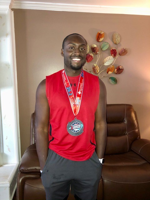 Photo of IT Support Associate, Joe Rice, wearing a medal after completing his first marathon.